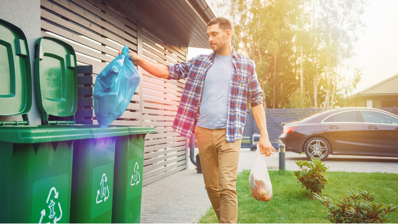 uomo che butta la spazzatura